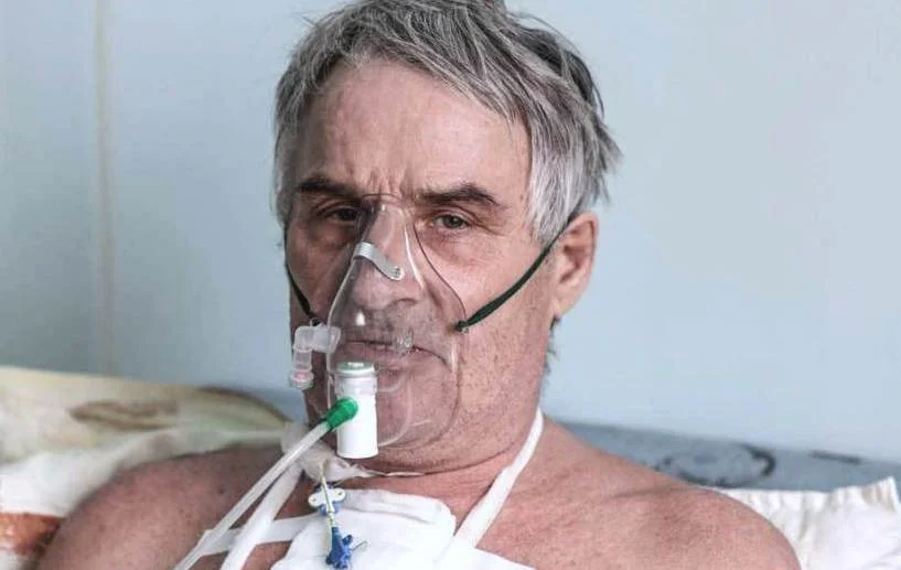 Person with oxygen mask in a hospital ward